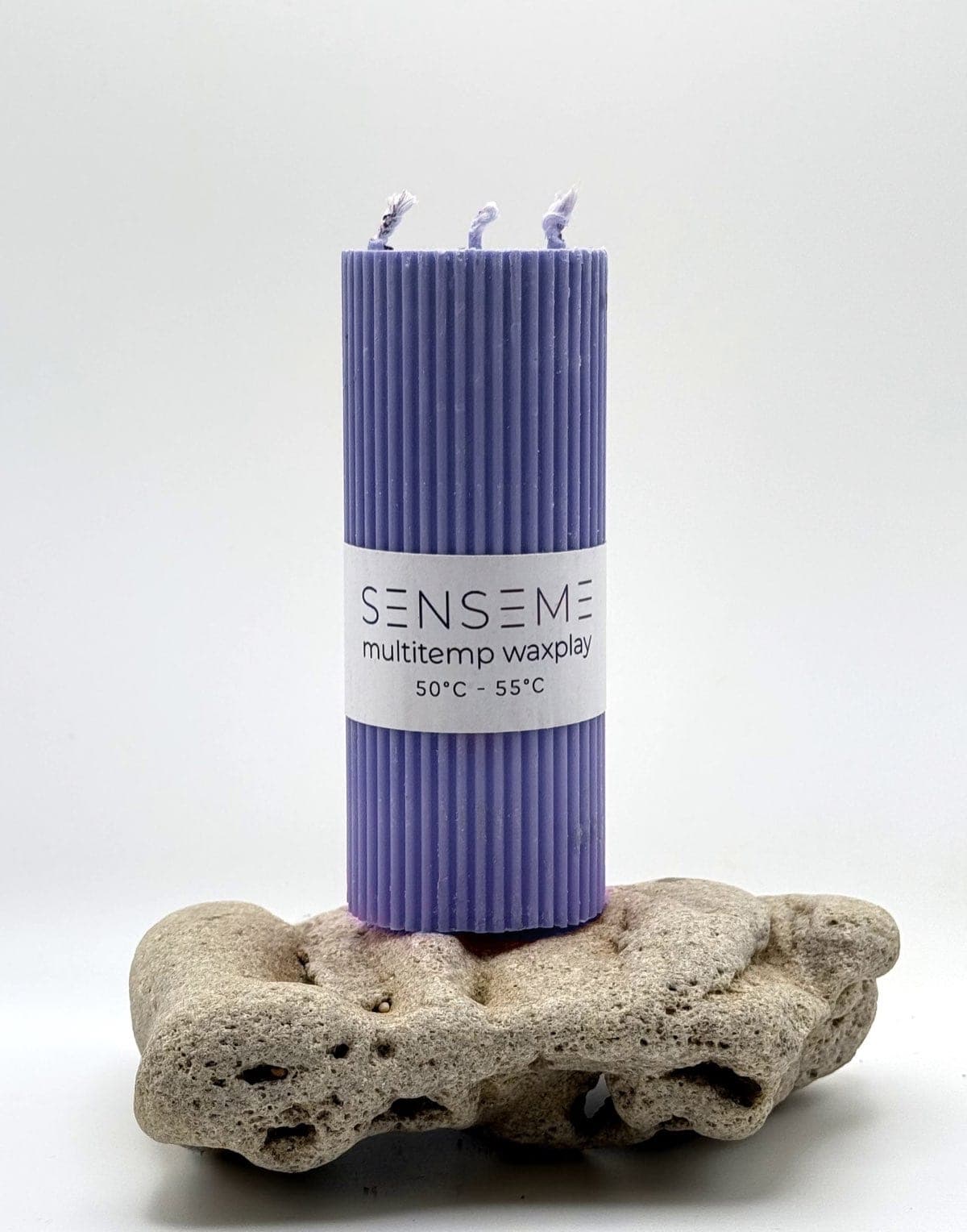 50°C Violet SenseMe wax play candle with three wicks on a stone — cannabis & cactus scent