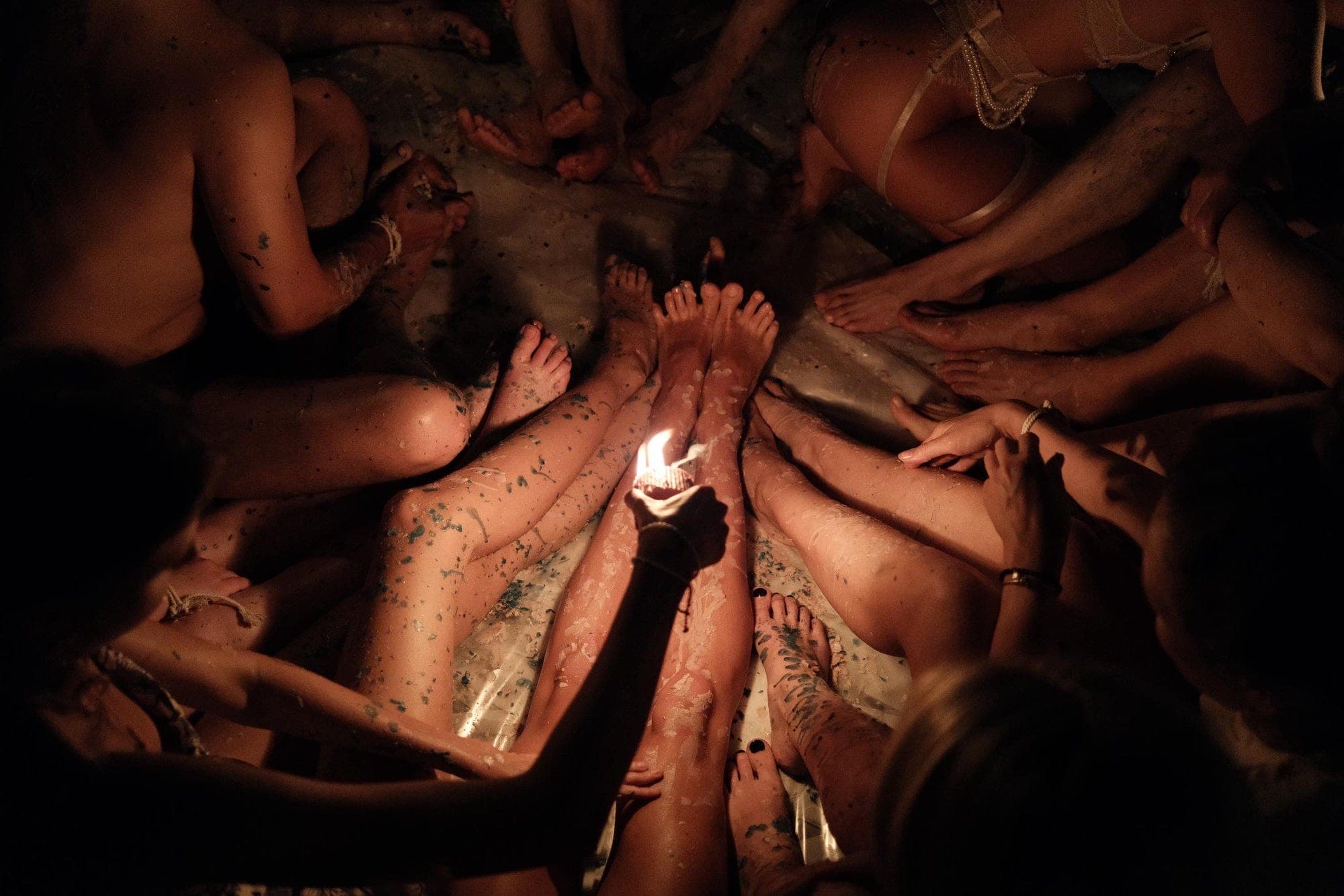 Participants sitting in a circle at a SenseMe wax play workshop, one holding a lit candle