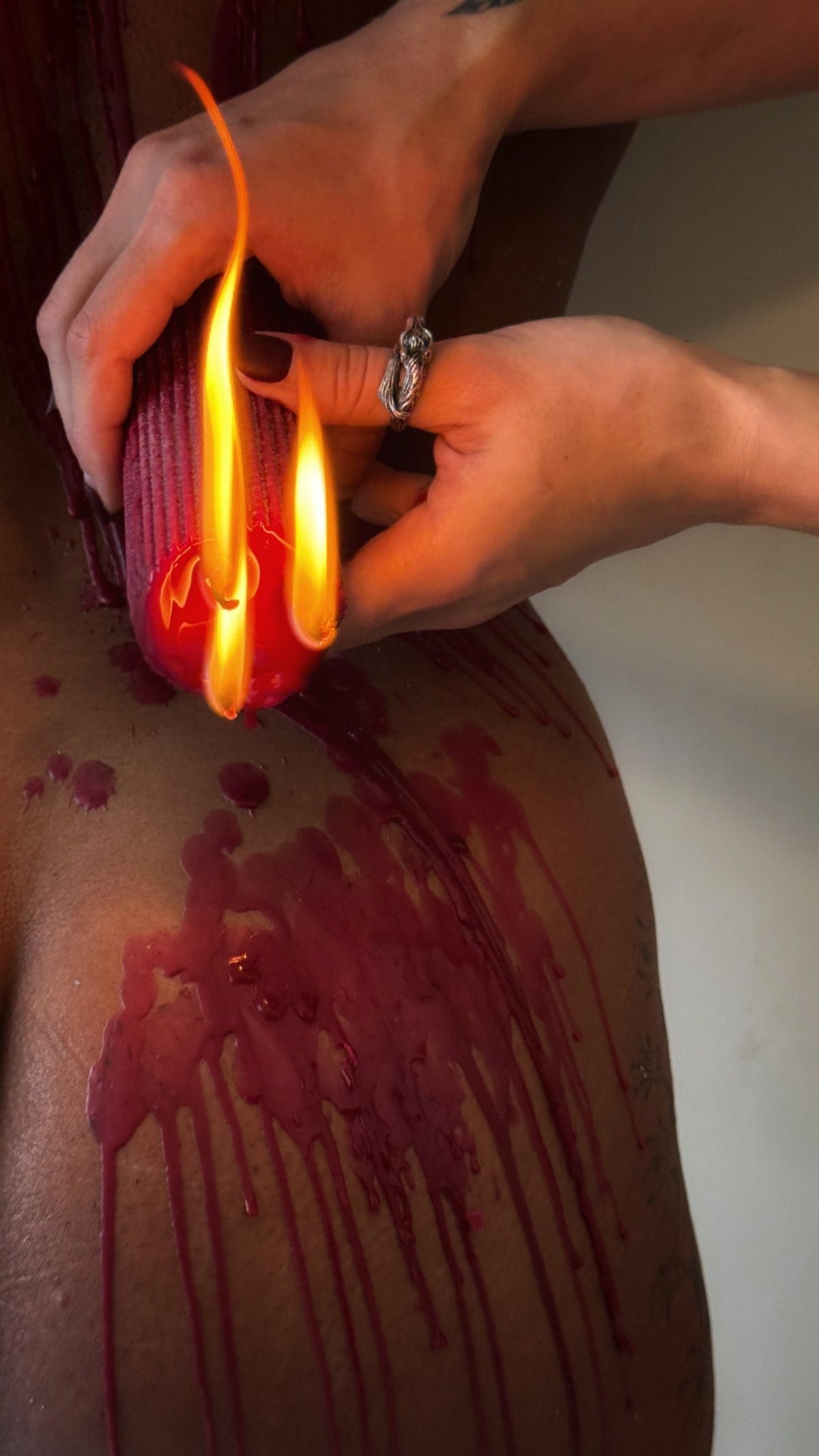 Medium temperature wax play candle setup illustrating controlled pour technique and distance awareness